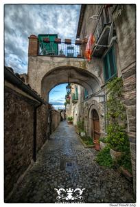 un callejón con un arco en un edificio antiguo en Hotel Italia & Lombardi, en Montefiascone