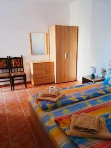 a bedroom with a bed with towels and a dresser at Guest House Bogat-Beden in Ravda