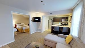a hotel room with a couch and a bedroom at Chase Suite Hotel Newark Fremont in Newark