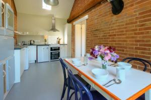 a kitchen with a table with a vase of flowers on it at The Dairy Cottage in Aldeburgh