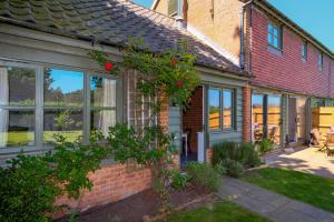 a house with large windows and a yard with a courtyard at The Dairy Cottage in Aldeburgh