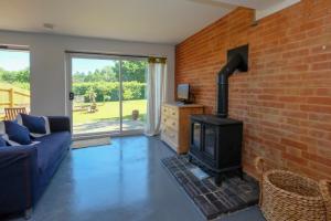 a living room with a brick wall and a wood stove at The Dairy Cottage in Aldeburgh