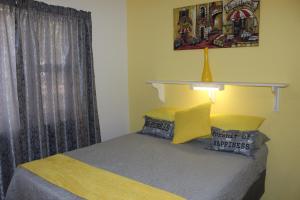 - une chambre avec un lit avec une étagère sur le mur dans l'établissement PhysEQFiT Guesthouse & Spa, à Centurion