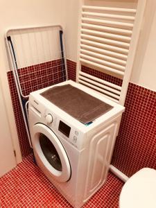 a washer and dryer in a red tiled bathroom at Carina Loft in Venice