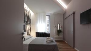 a white bedroom with a bed with towels on it at Suite Inn Rome in Rome