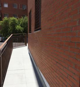 メリダにあるApartamento Ausonio 2 dormitoriosの歩道横の赤レンガ壁