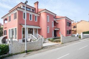 una casa rosa al lado de una calle en Villa Rose en Rovinj