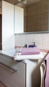 a bathroom with a sink and a purple towel at Apartments Dalmatino in Kaštela