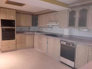 a kitchen with wooden cabinets and a stove top oven at Family Haclams in Zipaquirá