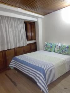ein Schlafzimmer mit einem Bett mit einer blauen und weißen Decke in der Unterkunft Family Haclams in Zipaquirá