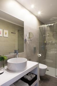 
a bathroom with a sink, toilet and bathtub at Virtudes City Lofts in Porto
