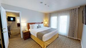 a hotel room with a large bed and a window at Chase Suite Hotel Newark Fremont in Newark +37 photos