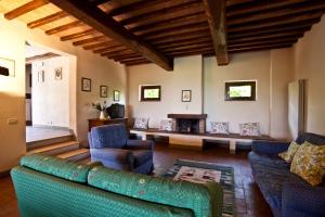 a living room with a couch and chairs and a table at Podere Il Pino in Poggibonsi