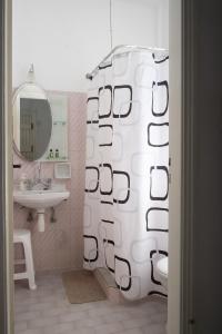 bagno con tenda per la doccia e lavandino di Nikoleta's Studios a Drios