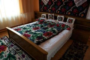a bed with flowers on it in a bedroom at La Vasile la Cazan in Mara +36 photos