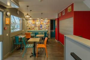 un restaurant avec des tables et des chaises colorées dans l'établissement hotelF1 Lyon Saint Priest, à Saint-Priest