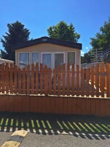 a wooden fence in front of a house at 32 Dayven Lodge in Boat of Garten