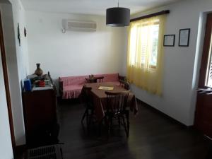 een woonkamer met een tafel en een roze bank bij Apartment Ivan in Cres