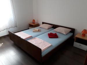 een slaapkamer met een bed met twee rode kussens erop bij Apartment Ivan in Cres