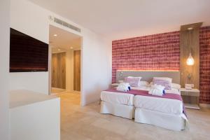 سرير أو أسرّة في غرفة في Hotel Bella Playa & Spa