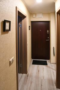 a hallway with a black door and a wooden floor at Relax Inn Druskininkai in Druskininkai