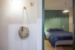 1 dormitorio con 1 cama y 1 bolsa colgada de la pared en CASA VECCHIA centre historique, en Bastia