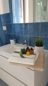 a bathroom with a sink with towels and flowers on it at La dimora di Nonno Nuccio in Ragusa
