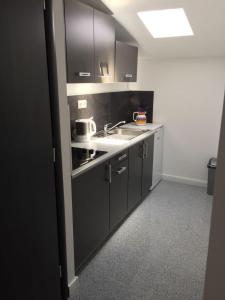 a kitchen with black cabinets and a sink at Apartment Silva in Vodice