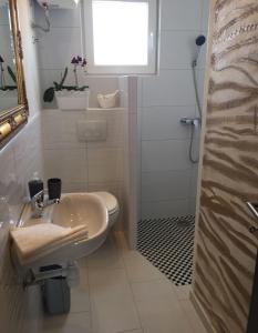baño con lavabo y aseo y ventana en Apartment Silva en Vodice