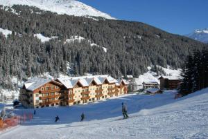 un gruppo di persone che sciano giù da una montagna innevata di Hotel Residence 3 Signori a Santa Caterina Valfurva