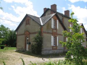 uma casa velha no meio de um campo em Gites du four saint Pierre em Angrie