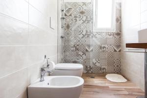 ein weißes Bad mit einem Waschbecken und einem WC in der Unterkunft Villa Leomaris in Torre dell'Orso