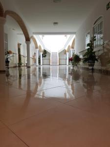 um corredor vazio de um edifício com piso em azulejo em Hostal Los Arcos em Chipiona