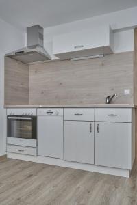 a kitchen with white cabinets and a stove top oven at Appartement Trujen in Längenfeld