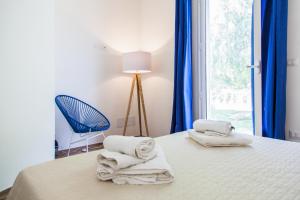 ein Schlafzimmer mit Handtüchern auf einem Bett mit Fenster in der Unterkunft Villa Leomaris in Torre dell'Orso