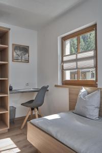 レンゲンフェルトにあるAppartement Trujenのベッドルーム1室(ベッド1台、椅子、窓付)