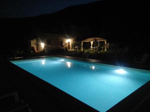 een groot blauw zwembad 's nachts bij Agriturismo Tre Monti in Meggiano