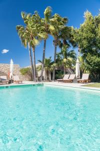 a swimming pool with chairs and palm trees at Son Gener Hotel Spa in Son Servera
