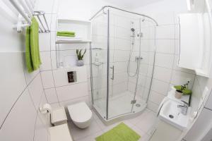 コウォブジェクにあるPrzytulny Apartament Kołobrzeg - Podczeleの白いバスルーム(シャワー、トイレ付)