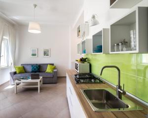 una cocina con fregadero y un sofá en una habitación en Gi HOME Apartment vicino alla stazione e al Mare, en Meta