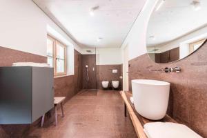 a bathroom with two toilets and a large mirror at Obersteinerhof in Collalbo