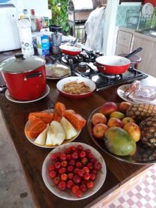 a table with plates of fruits and vegetables on it at Irradiante in Olinda