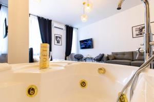 a bathroom with a bath tub and a living room at Mun&igrave; Boutique Flat by Babylon Stay in Naples