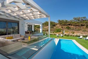 a villa with a swimming pool and a house at Eolia Iconic Villa, walking distance to the beach, By ThinkVilla in Panormos Rethymno