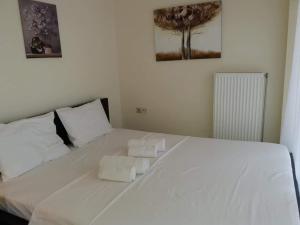 a bedroom with a white bed with towels on it at Functional Studio in Sepolia Athens in Athens