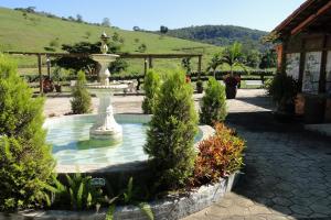 a fountain in the middle of a garden at Hotel dos Bretões in Sapucaia