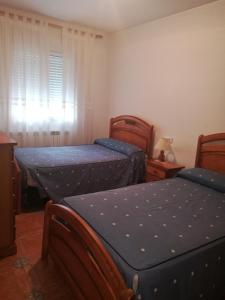 a bedroom with two twin beds and a window at Casa y Apartamentos Nati in Carrascosa