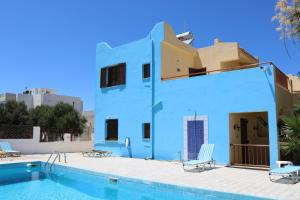 a blue house with a swimming pool in front of it at Alex Home Apartments in Hersonissos