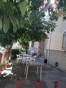 una mesa de picnic y sillas bajo un árbol en Casa y Apartamentos Nati, en Carrascosa