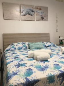 1 dormitorio con 1 cama con edredón azul y blanco en La Casa Dell'Amore Perfetto, en Génova